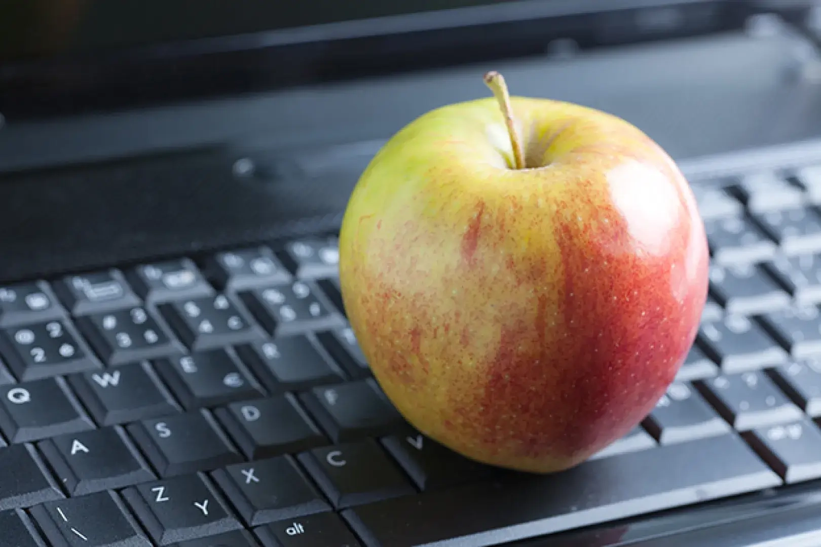 Apfel liegt auf einer Laptoptastatur